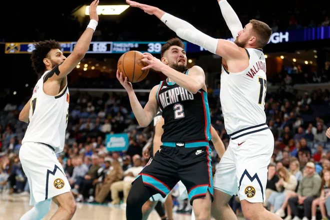 Mar 18, 2026; Memphis, Tennessee, USA; Memphis Grizzlies guard Ty Jerome (2) drives to the basket as Denver Nuggets guard Jamal Murray (27) and center Jonas Valanciunas (17) defend during the second quarter at FedExForum. Mandatory Credit: Petre Thomas-Imagn Images