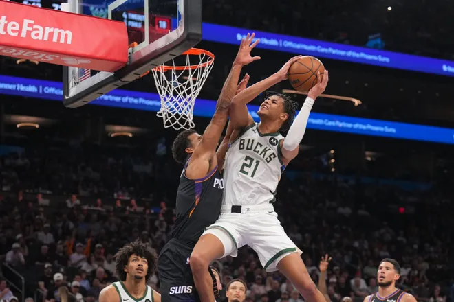 Mar 21, 2026; Phoenix, Arizona, USA; Milwaukee Bucks forward Ousmane Dieng (21) goes up for a layup against Phoenix Suns forward Oso Ighodaro (11) during the second half at Mortgage Matchup Center. Mandatory Credit: Joe Camporeale-Imagn Images