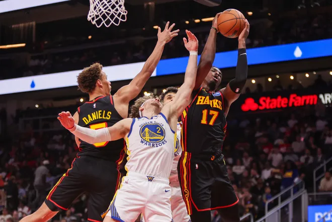Mar 21, 2026; Atlanta, Georgia, USA; Atlanta Hawks forward Onyeka Okongwu (17) grabs a rebound past Golden State Warriors guard Brandin Podziemski (2) in the fourth quarter at State Farm Arena. Mandatory Credit: Brett Davis-Imagn Images