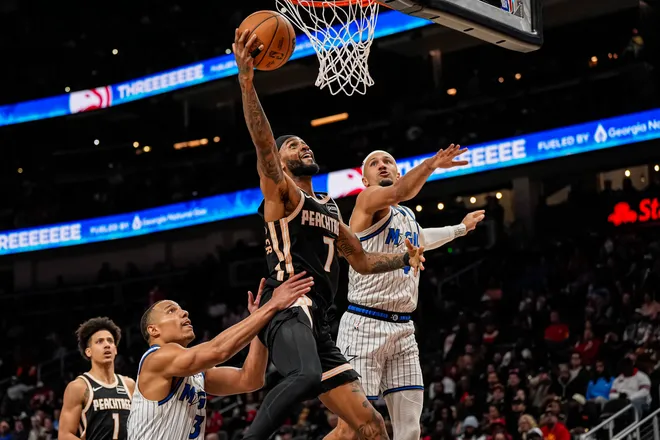 Mar 16, 2026; Atlanta, Georgia, USA; Atlanta Hawks guard Nickeil Alexander-Walker (7) scores behind Orlando Magic guards Desmond Bane (3) and Jalen Suggs (4) during the second half at State Farm Arena. Mandatory Credit: Dale Zanine-Imagn Images