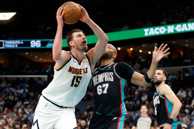 Mar 18, 2026; Memphis, Tennessee, USA; Denver Nuggets center Nikola Jokic (15) drives to the basket as Memphis Grizzlies forward Taj Gibson (67) defends during the third quarter at FedExForum. Mandatory Credit: Petre Thomas-Imagn Images