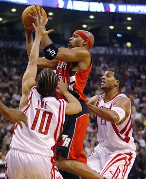 TORONTO - NOVEMBER 3: Vince Carter #15 of the Toronto Raptors takes a shot as he is surrounded by Tyronn Lue #10 and Jim Jackson #21 both of the Houston Rockets during a game at the Air Canada Centre on November 3, 2003 in Toronto, Canada. The Raptors won the game 95-88. NOTE TO USER: User expressly acknowledges and agrees that, by downloading and or using this photograph, User is consenting to the terms and conditions of the Getty Images License Agreement. (Photo by Dave Sandford/Getty Images)