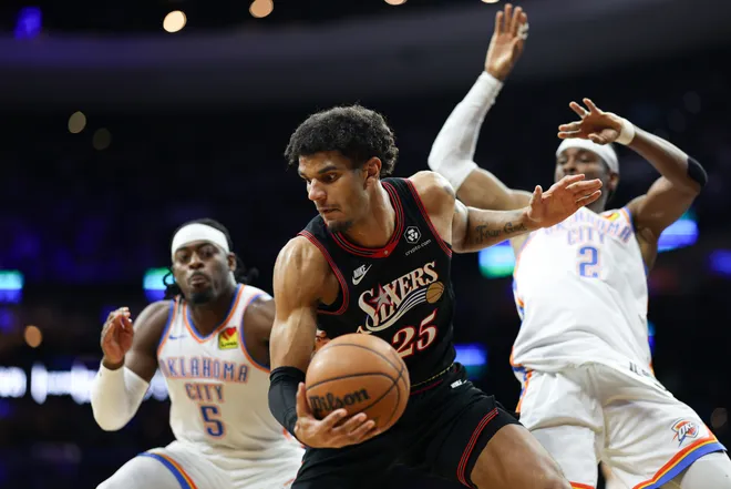 Mar 23, 2026; Philadelphia, Pennsylvania, USA; Philadelphia 76ers forward Dominick Barlow (25) controls the ball against Oklahoma City Thunder guard Shai Gilgeous-Alexander (2) and guard Luguentz Dort (5) during the second quarter at Xfinity Mobile Arena. Mandatory Credit: Bill Streicher-Imagn Images