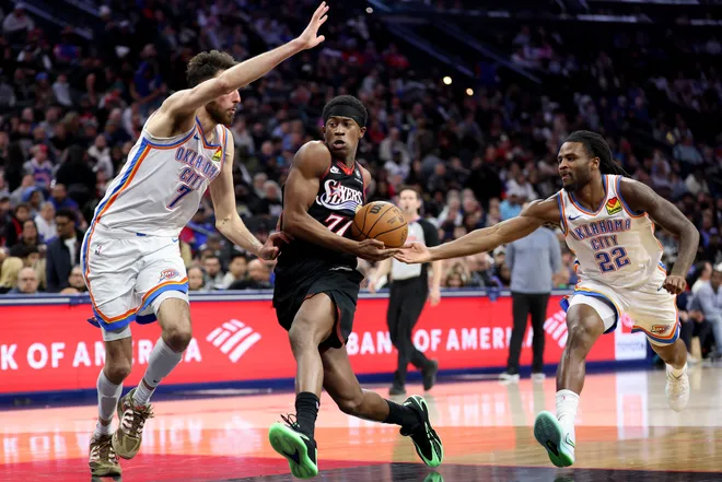 PHILADELPHIA, PENNSYLVANIA - MARCH 23: Vj Edgecombe #77 of the Philadelphia 76ers drives past Chet Holmgren #7 of the Oklahoma City Thunder during the second half at Xfinity Mobile Arena on March 23, 2026 in Philadelphia, Pennsylvania. NOTE TO USER: User expressly acknowledges and agrees that, by downloading and or using this photograph, User is consenting to the terms and conditions of the Getty Images License Agreement. (Photo by Emilee Chinn/Getty Images)