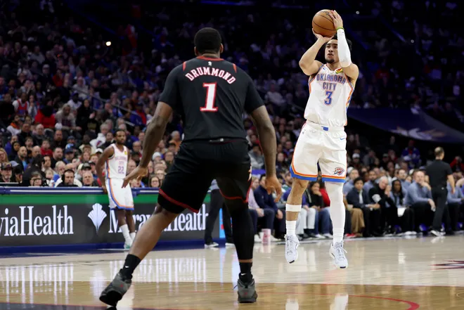 PHILADELPHIA, PENNSYLVANIA - MARCH 23: Jared McCain #3 of the Oklahoma City Thunder shoots a three-pointer against Andre Drummond #1 of the Philadelphia 76ers during the first half at Xfinity Mobile Arena on March 23, 2026 in Philadelphia, Pennsylvania. NOTE TO USER: User expressly acknowledges and agrees that, by downloading and or using this photograph, User is consenting to the terms and conditions of the Getty Images License Agreement. (Photo by Emilee Chinn/Getty Images)