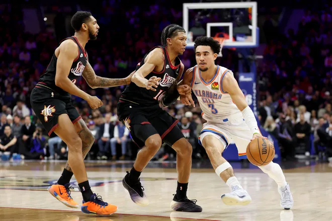 PHILADELPHIA, PENNSYLVANIA - MARCH 23: Jared McCain #3 of the Oklahoma City Thunder drives past Marjon Beauchamp #16 of the Philadelphia 76ers during the first half at Xfinity Mobile Arena on March 23, 2026 in Philadelphia, Pennsylvania. NOTE TO USER: User expressly acknowledges and agrees that, by downloading and or using this photograph, User is consenting to the terms and conditions of the Getty Images License Agreement. (Photo by Emilee Chinn/Getty Images)