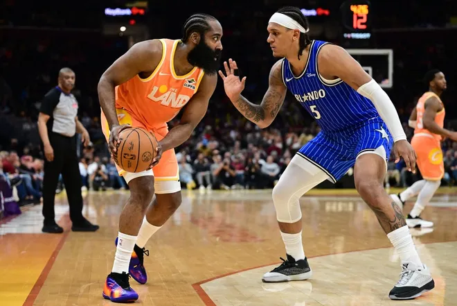 Mar 24, 2026; Cleveland, Ohio, USA; Cleveland Cavaliers guard James Harden (1) looks to dribble while being guarded by Orlando Magic forward Paolo Banchero (5) during the second half at Rocket Arena.
