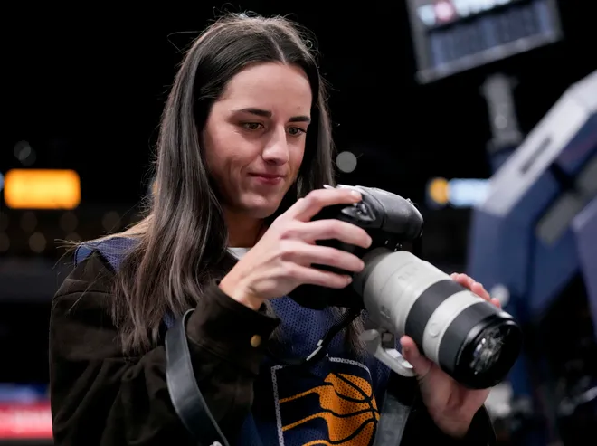 Indiana Fever guard Caitlin Clark takes photographs Wednesday, March 25, 2026, during a game against the Los Angeles Lakers at Gainbridge Fieldhouse in Indianapolis.