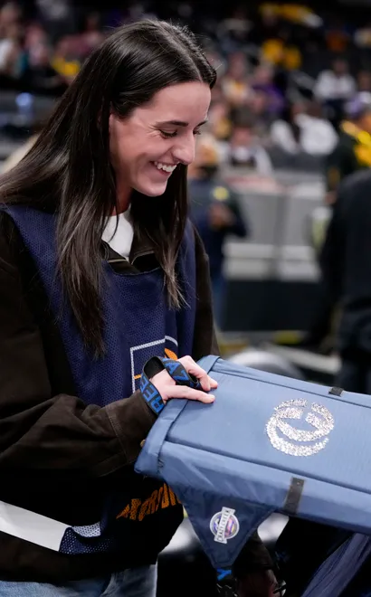 Indiana Fever guard Caitlin Clark looks at at folding seat adorned with her logo Wednesday, March 25, 2026, ahead of a game against the Los Angeles Lakers at Gainbridge Fieldhouse in Indianapolis.