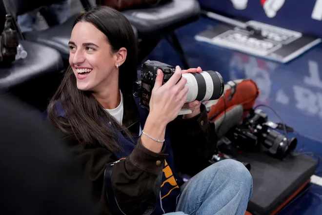 Indiana Fever guard Caitlin Clark takes photographs Wednesday, March 25, 2026, during a game against the Los Angeles Lakers at Gainbridge Fieldhouse in Indianapolis.