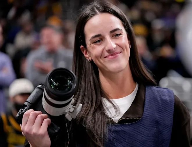 Indiana Fever guard Caitlin Clark takes photographs Wednesday, March 25, 2026, during a game against the Los Angeles Lakers at Gainbridge Fieldhouse in Indianapolis.
