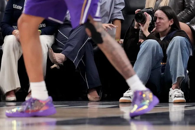 Indiana Fever guard Caitlin Clark takes photographs Wednesday, March 25, 2026, during a game against the Los Angeles Lakers at Gainbridge Fieldhouse in Indianapolis.