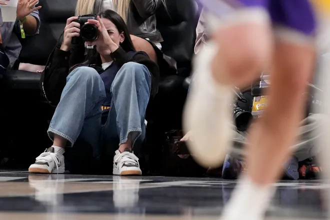 Indiana Fever guard Caitlin Clark takes photographs Wednesday, March 25, 2026, during a game against the Los Angeles Lakers at Gainbridge Fieldhouse in Indianapolis.