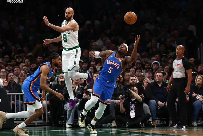 Mar 25, 2026; Boston, Massachusetts, USA; Oklahoma City Thunder guard Luguentz Dort (5) goes for a rebound past Boston Celtics guard Derrick White (9) during the second quarter at TD Garden. Mandatory Credit: Winslow Townson-Imagn Images
