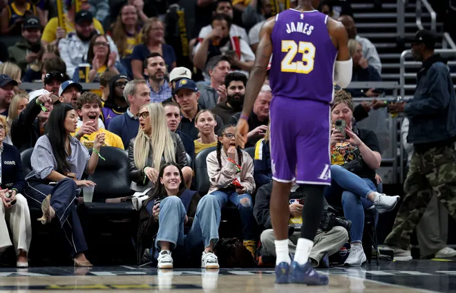 INDIANAPOLIS, INDIANA - MARCH 25: Caitlin Clark of the Indiana Fever sits on the baseline and makes photographs during the Indiana Pacers game against the Los Angeles Lakers at Gainbridge Fieldhouse on March 25, 2026, in Indianapolis, Indiana. NOTE TO USER: User expressly acknowledges and agrees that, by downloading and or using this photograph, User is consenting to the terms and conditions of the Getty Images License Agreement (Photo by Andy Lyons/Getty Images)