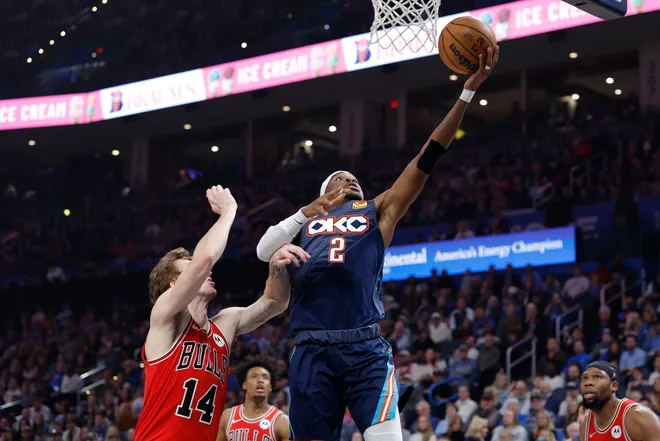 Mar 27, 2026; Oklahoma City, Oklahoma, USA; Oklahoma City Thunder guard Shai Gilgeous-Alexander (2) goes to the basket beside Chicago Bulls forward Matas Buzelis (14) during the first half at Paycom Center. Mandatory Credit: Alonzo Adams-Imagn Images