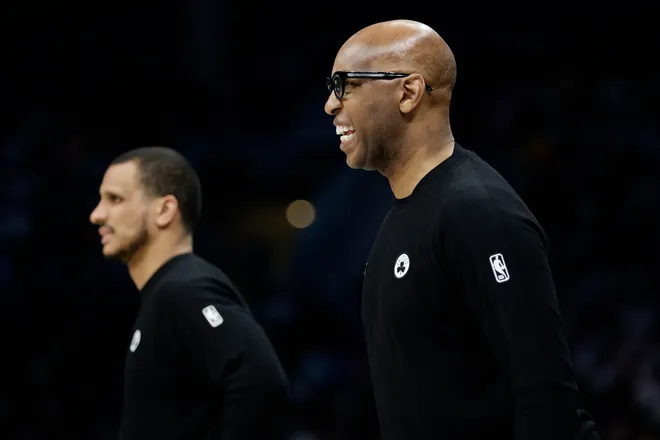 Mar 29, 2026; Charlotte, North Carolina, USA; Boston Celtics assistant coach Sam Cassell (right) watches from the sideline during the second half against the Charlotte Hornets at Spectrum Center. Mandatory Credit: Brian Westerholt-Imagn Images