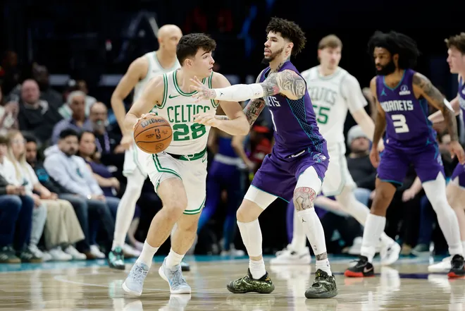 Mar 29, 2026; Charlotte, North Carolina, USA; Boston Celtics guard Hugo González (28) keeps the ball away from Charlotte Hornets guard LaMelo Ball (1) during the second half at Spectrum Center. Mandatory Credit: Brian Westerholt-Imagn Images