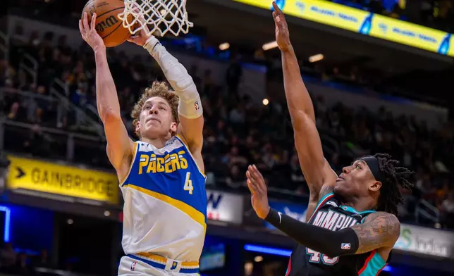 Indiana Pacers guard Taelon Peter (4) goes up to dunk during the second half of an NBA basketball game against the Memphis Grizzlies in Indianapolis, Sunday, March 1, 2026. (AP Photo/Doug McSchooler)