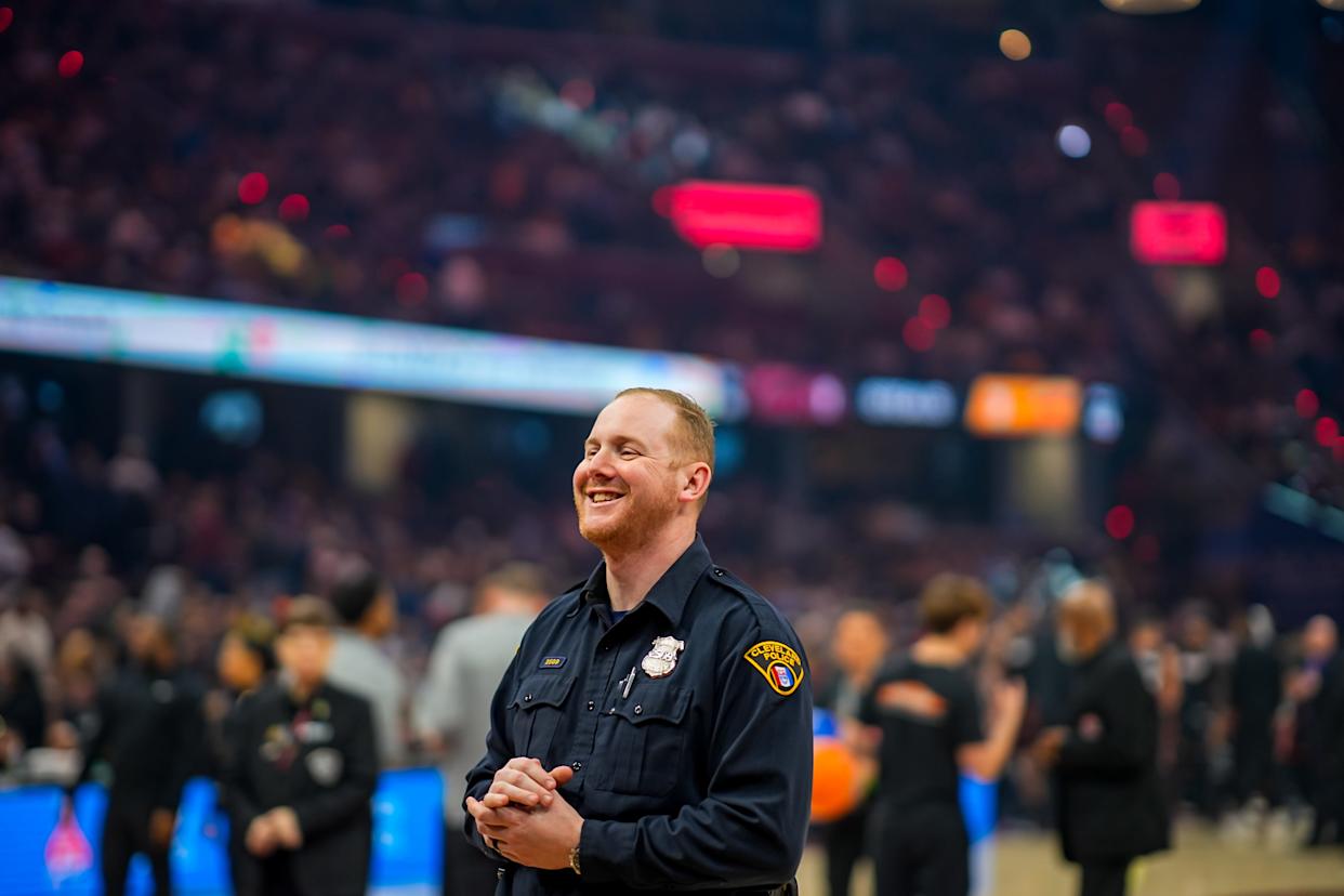 Police officer Chris Porter cracks a smile while working his post during a timeout in the Cleveland Cavaliers game against the Miami Heat,