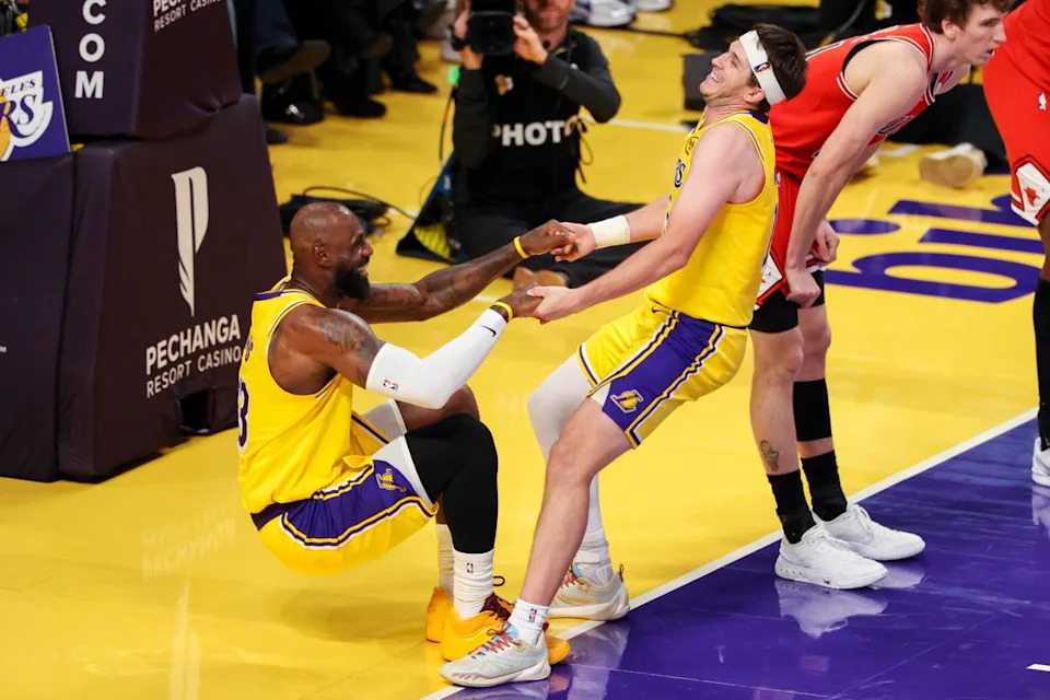 Austin Reaves #15 of the Los Angeles Lakers picks up LeBron James #23 of the Los Angeles Lakers after a play during an NBA basketball game against the Chicago Bulls, Thursday March 12, 2026 in Los Angeles, Calif.