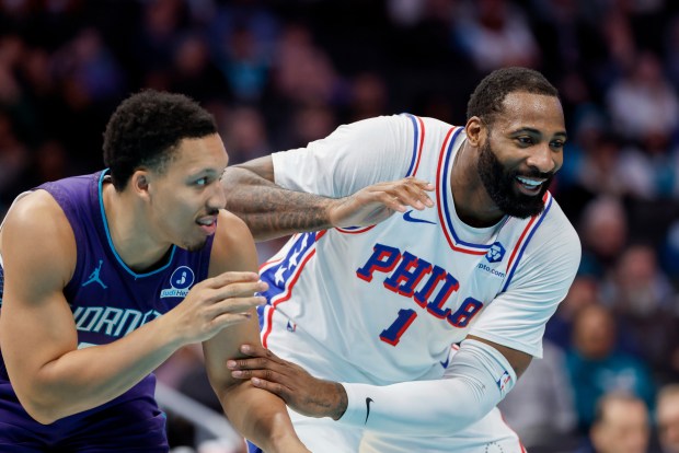 Charlotte Hornets forward Grant Williams, left, and Philadelphia 76ers center Andre Drummond laugh as they stands on the court during the second half of an NBA basketball game in Charlotte, N.C., Monday, Jan. 26, 2026. (AP Photo/Nell Redmond)