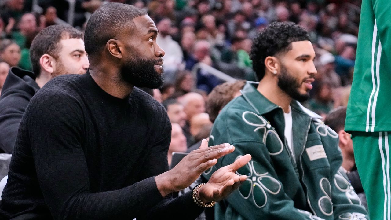 Boston Celtics guard Jaylen Brown, left, applauds while seated alongside forward Jayson Tatum, who both did not play, during the first half of an NBA basketball game against the Sacramento Kings, Friday, Jan. 30, 2026, in Boston. (AP Photo/Charles Krupa)