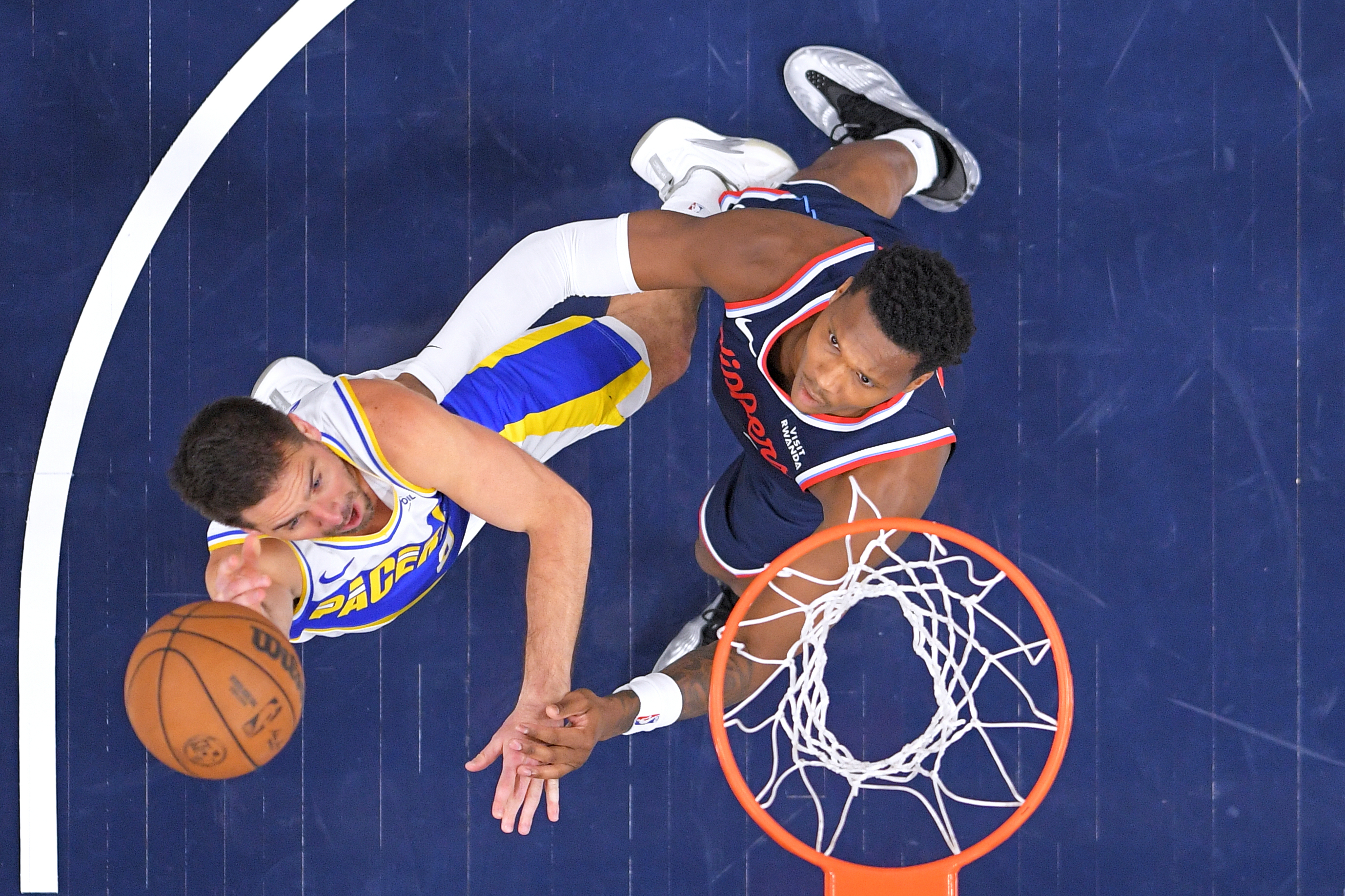 Indiana Pacers guard T.J. McConnell, left, shoots as Clippers guard...