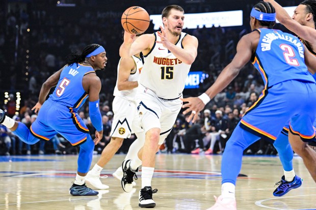 Denver Nuggets center Nikola Jokić (15) passes the ball during the first half of an NBA basketball game against the Oklahoma City Thunder, Monday, Mar. 9, 2026, in Oklahoma City. (AP Photo/Gerald Leong)