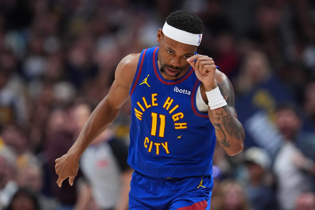 Denver Nuggets guard Bruce Brown gestures by tipping his hat after hitting a 3-point basket against the Golden State Warriors in the second half of an NBA basketball game Sunday, March 29, 2026, in Denver. (AP Photo/David Zalubowski)