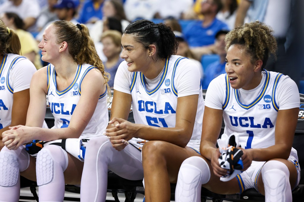 Gianna Kneepkens, Lauren Betts, and Kiki Rice reacting from the bench during a basketball game.