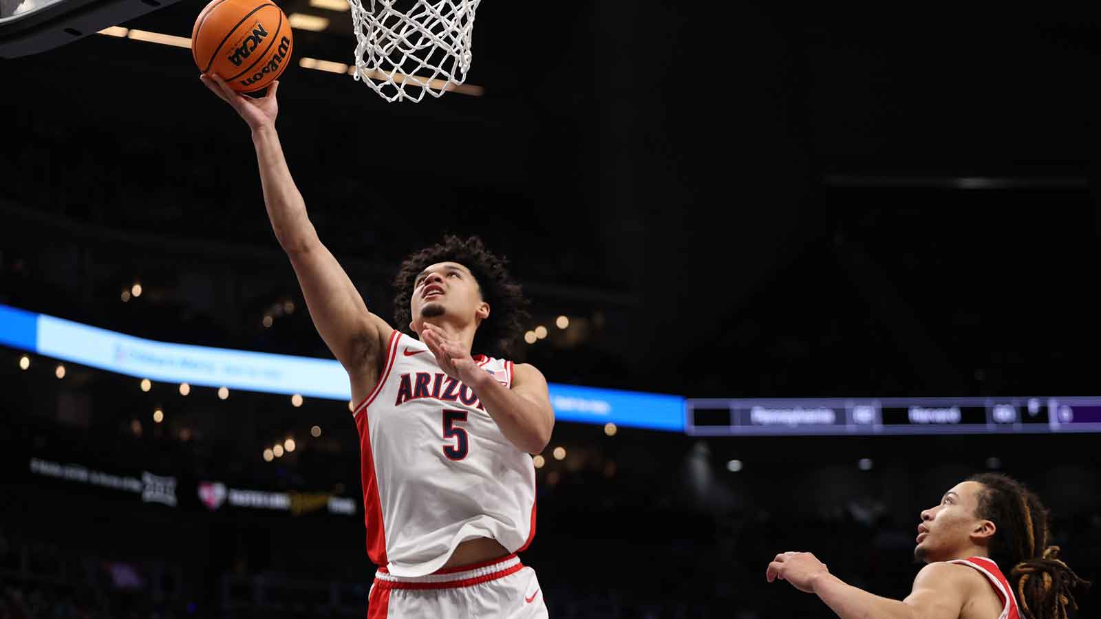 Arizona Wildcats guard Brayden Burries (5) drives to the hoop past Houston Cougars guard Kingston Flemings (4) during the first half during the men's Big 12 Conference Tournament Championship at T-Mobile Center. 