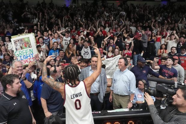 Saint Mary's guard Mikey Lewis (0) celebrates with fans after a victory against Gonzaga in a NCAA college basketball game in Moraga, Calif., Saturday, Feb. 28, 2026. (AP Photo/Tony Avelar)