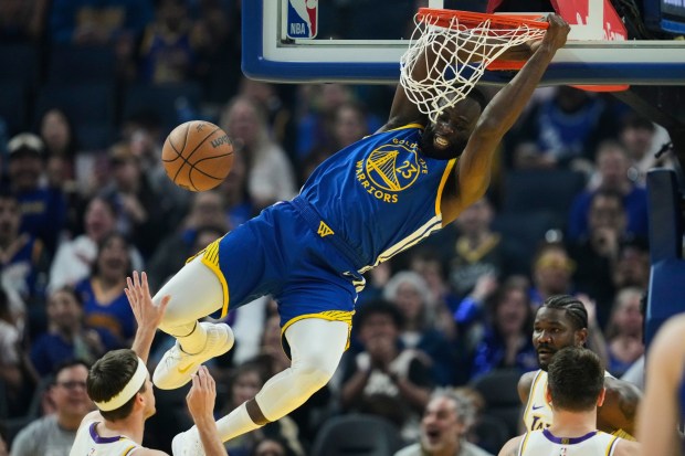 Golden State Warriors forward Draymond Green (23) dunks next to Los Angeles Lakers guard Austin Reaves, left, during the first half of an NBA basketball game, Saturday, Feb. 28, 2026, in San Francisco. (AP Photo/Godofredo A. Vásquez)