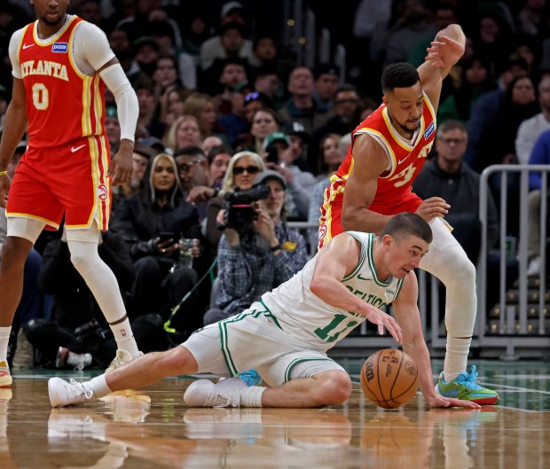 Boston Celtics guard Payton Pritchard goes to the floor against Atlanta Hawks guard CJ McCollum at the TD Garden. (Staff photo by Stuart Cahill/MediaNews Group)