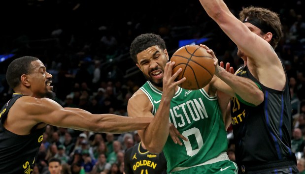 Boston Celtics forward Jayson Tatum is tied up by Golden State Warriors guard De'anthony Melton, left, and center Quinten Post on Wednesday night. (Staff photo by Stuart Cahill)