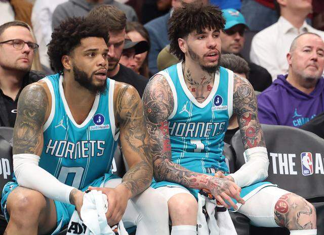 Charlotte Hornets forward Miles Bridges, left, and guard LaMelo Ball sit on the team’s bench late in game action against the Cleveland Cavaliers at Spectrum Center in Charlotte, North Carolina, on Jan. 21, 2026. The Cavaliers defeated the Hornets 94-87.