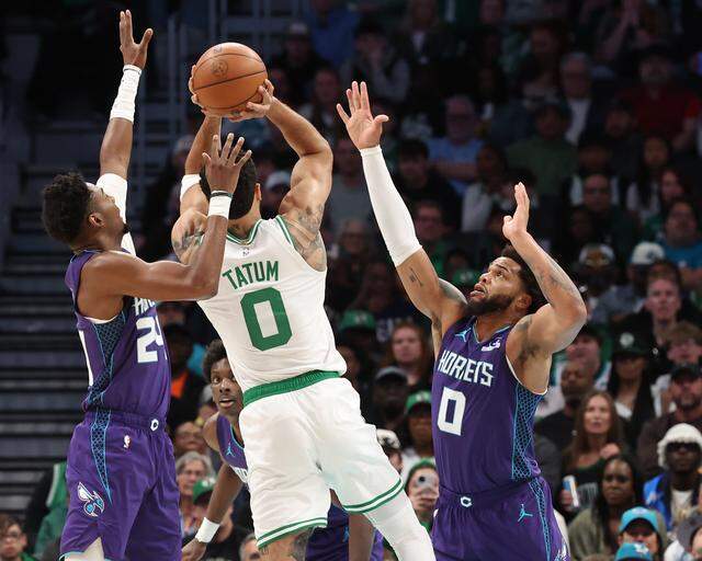 Charlotte Hornets guard Brandon Miller, left and forward Miles Bridges, right, attempt to stop Boston Celtics forward Jayson Tatum's shot, center, during action at Spectrum Center in Charlotte, NC on Sunday, March 29, 2026.