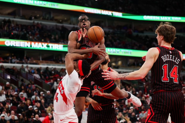 Chicago Bulls forward Jalen Smith (25) fouls Toronto Raptors guard Ja'kobe Walter (14) during the first quarter at the United Center March 18, 2026 in Chicago. (Armando L. Sanchez/Chicago Tribune)