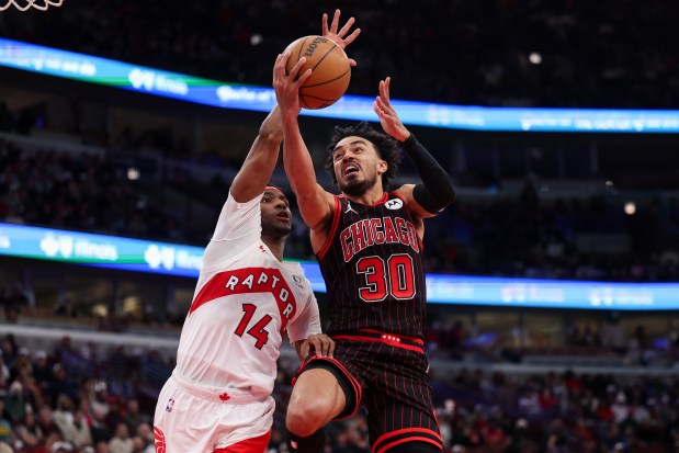 Toronto Raptors guard Ja'kobe Walter (14) guards Chicago Bulls guard Tre Jones (30) while he goes up to the basket during the third quarter at the United Center March 18, 2026 in Chicago. (Armando L. Sanchez/Chicago Tribune)