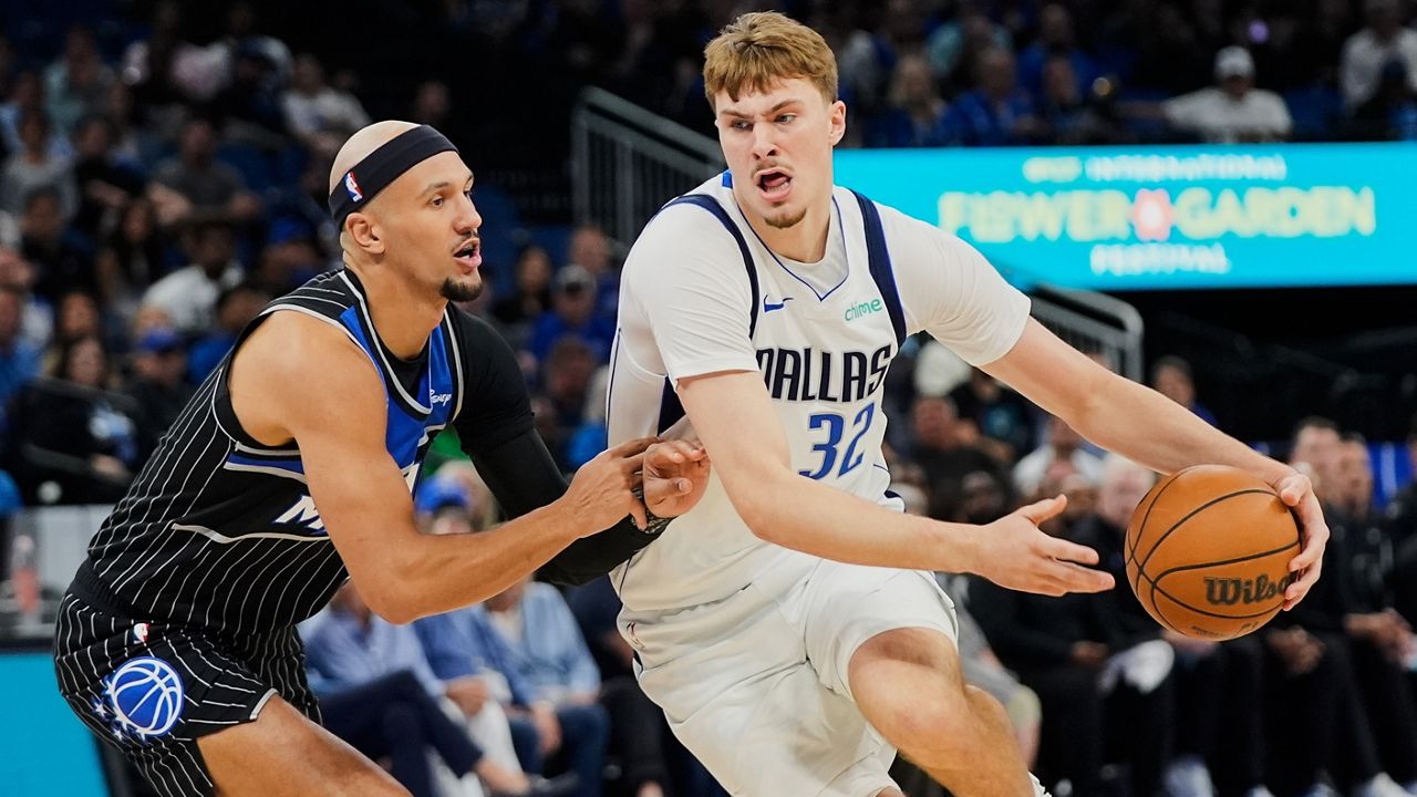 Dallas Mavericks forward Cooper Flagg (32) drives past Orlando Magic guard Jalen Suggs, left, during the first half of an NBA basketball game, Thursday, March 5, 2026, in Orlando, Fla. (AP Photo/John Raoux)
