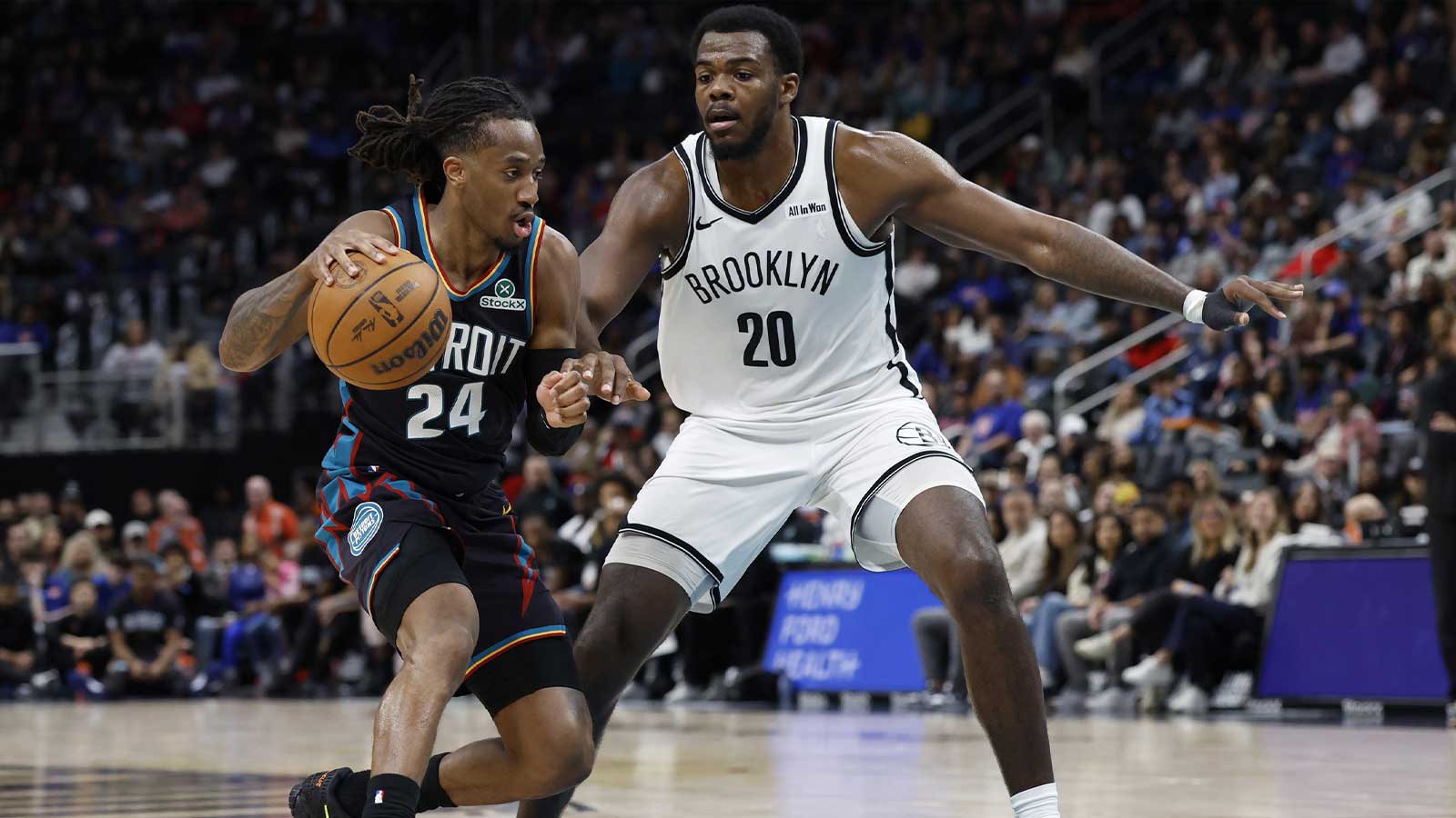 Detroit Pistons guard Daniss Jenkins (24) dribbles defended by Brooklyn Nets center Day'ron Sharpe (20) in the second half at Little Caesars Arena.