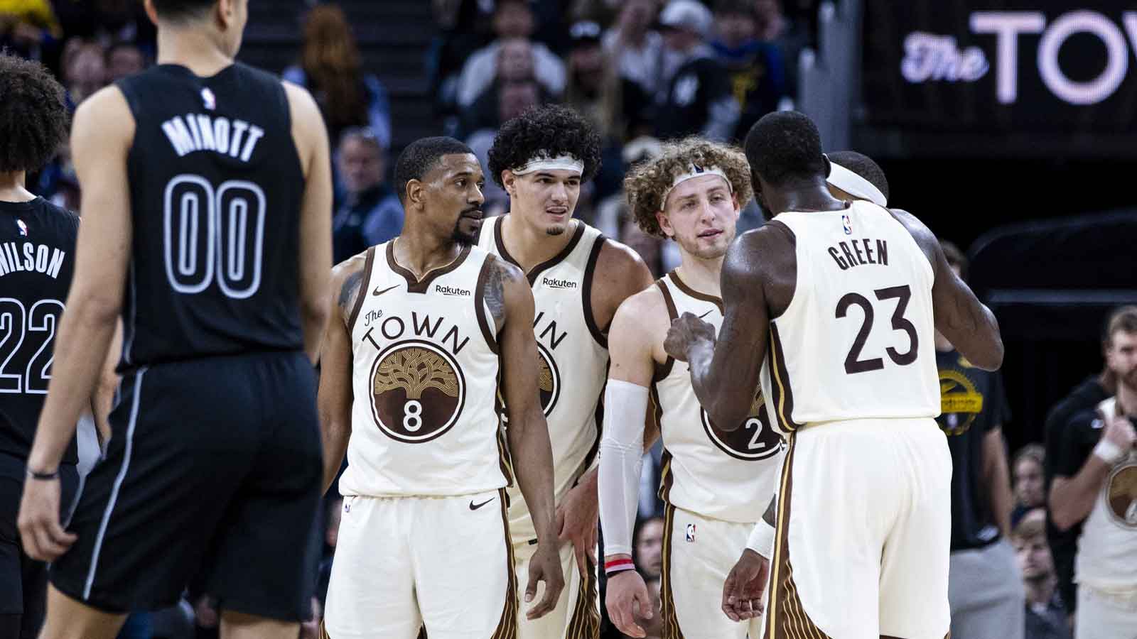 Golden State Warriors forward Draymond Green (23) talks to guard De'anthony Melton (8) and guard Brandin Podziemski (2) and forward Gui Santos (15) during the fourth quarter against the Brooklyn Nets at Chase Center.