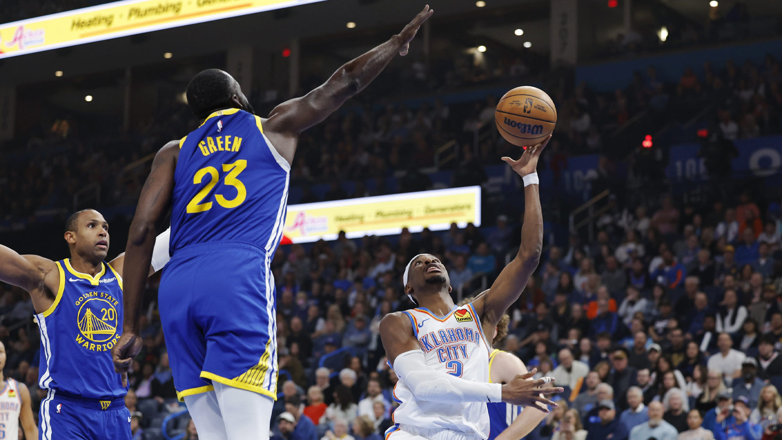 Oklahoma City Thunder guard Shai Gilgeous-Alexander (2) shoots as Golden State Warriors forward Draymond Green (23) defends during the first half at Paycom Center.