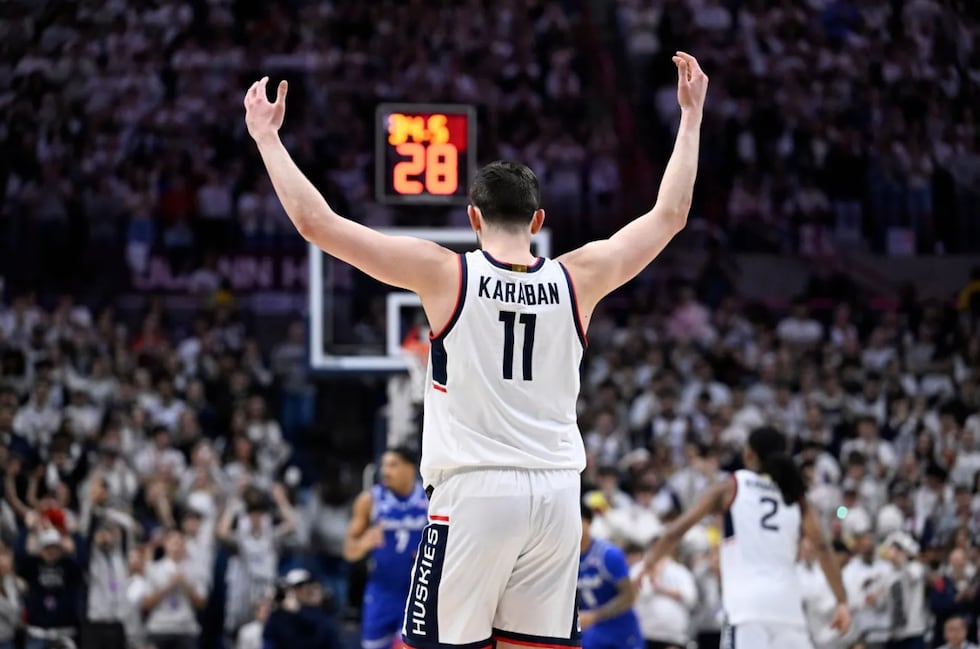 UConn forward Alex Karaban (11) raises his arms in the first half of an NCAA college...