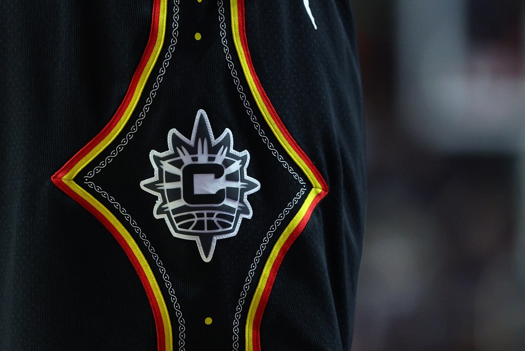 Close-up of a Connecticut Sun uniform with a logo featuring a large "C" and a basketball within a starburst design.