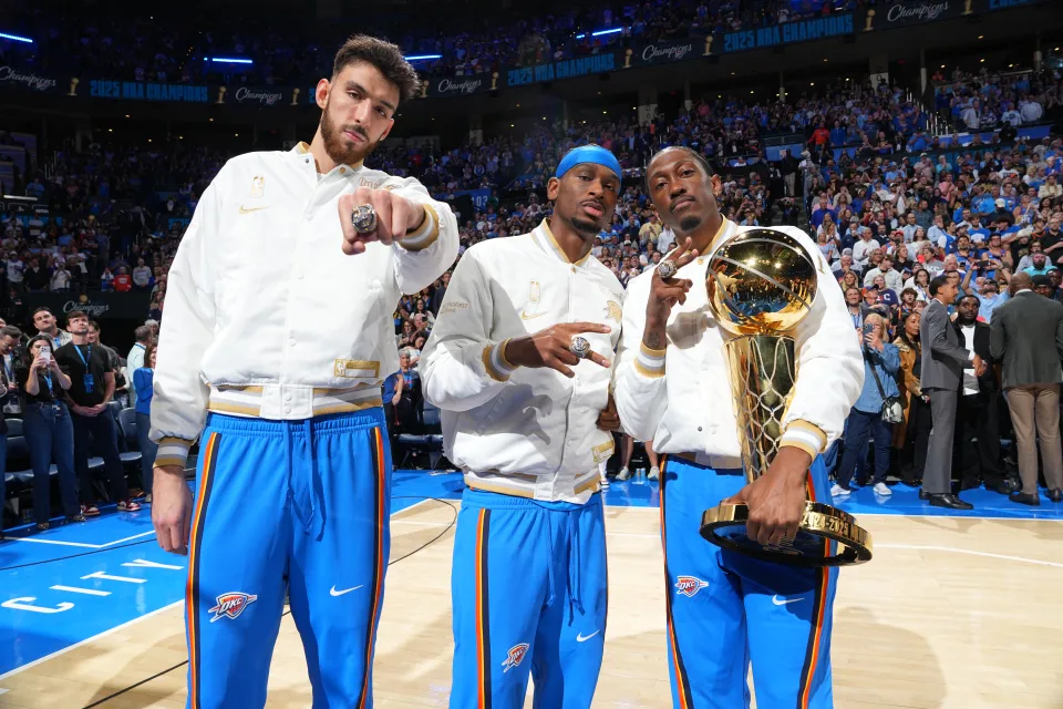 Chet Holmgren, Shai Gilgeous-Alexander and Jalen Williams of the Oklahoma City Thunder pose for a photo with the Larry O'Brien Trophy before the game against the Houston Rockets