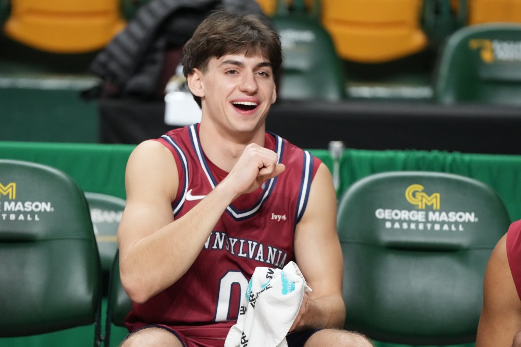 UPenn basketball player smiling on the bench during the UPenn v George Mason game.