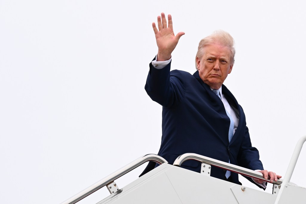 Donald Trump waves as he boards Air Force One on March 20, 2026 at Joint Base Andrews, Maryland to spend another weekend at his Mar-a-Lago resort. 