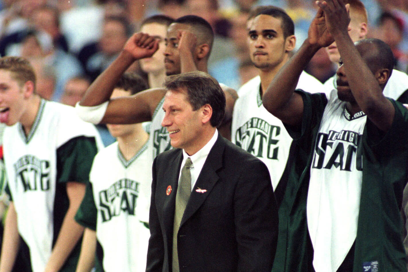 Tom Izzo smiles in front of Michigan State basketball players in 2000